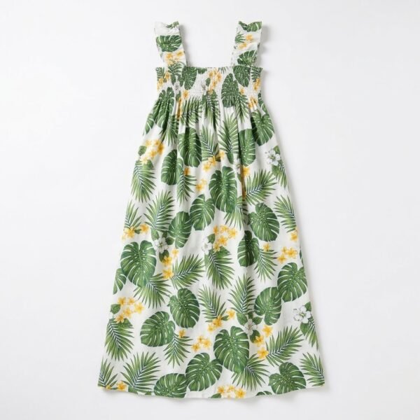 White muumuu dress with green monstera and palm leaf print, ruffle straps and smocked bodice